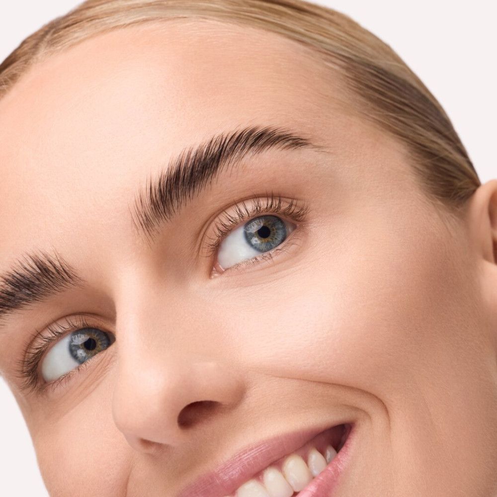 Nahaufnahme eines Gesichts mit betonten Augenbrauen. Die Augenbrauen sind nach oben gebürstet und wirken voller. Blaue Augen, helle Haut.