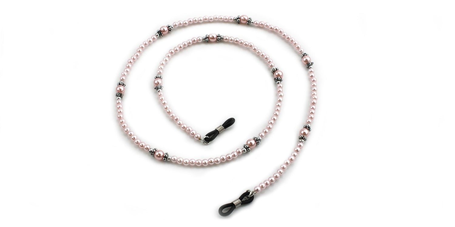 Brillenkette mit rosa Perlen und schwarzen Enden. Die Kette ist in einer Spirale angeordnet.