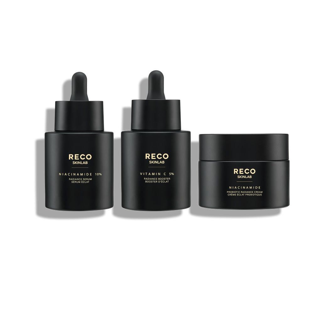 Drei schwarze Flakons und ein Tiegel. Aufschrift: RECO SKINLAB. Produkte: Niacinamide 10%, Vitamin C 5%, Niacinamide. Tropfer und Deckel.