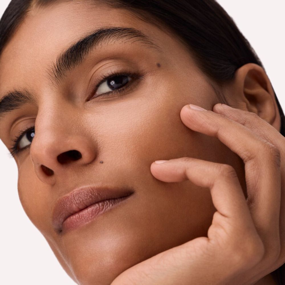 Nahaufnahme eines Gesichts. Die Person berührt ihr Gesicht mit der Hand. Keine Produkte sichtbar.