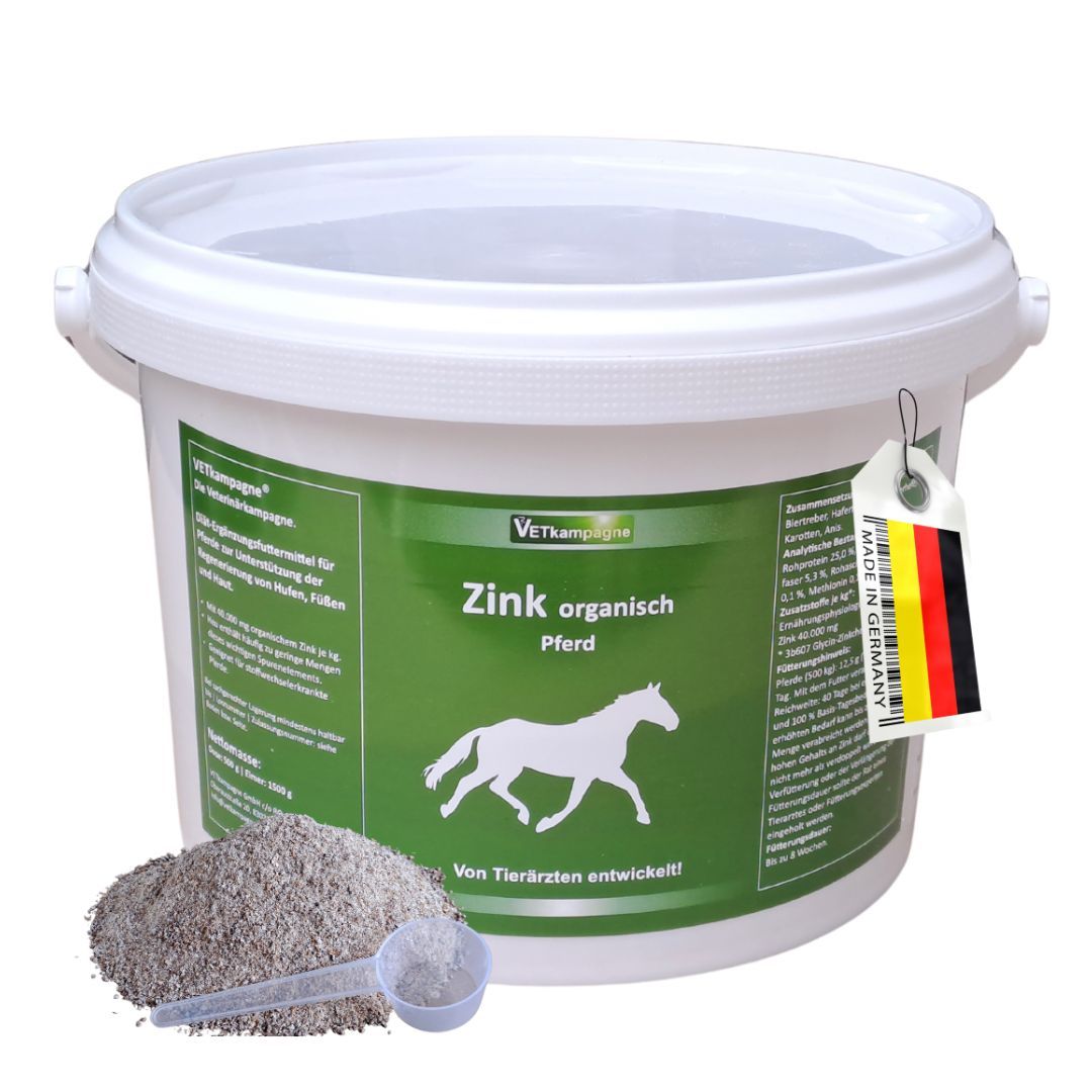 Weißer Eimer mit grünem Etikett. Aufschrift: Zink organisch Pferd. Neben dem Eimer ein Haufen Pulver und ein Messlöffel.