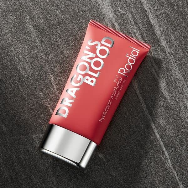 Rote Tube mit weißer Schrift. Aufschrift: DRAGON'S BLOOD, Rodial. Silberfarbener Verschluss. Produktname: Hyaluronic Moisturiser. Auf grauem Untergrund.
