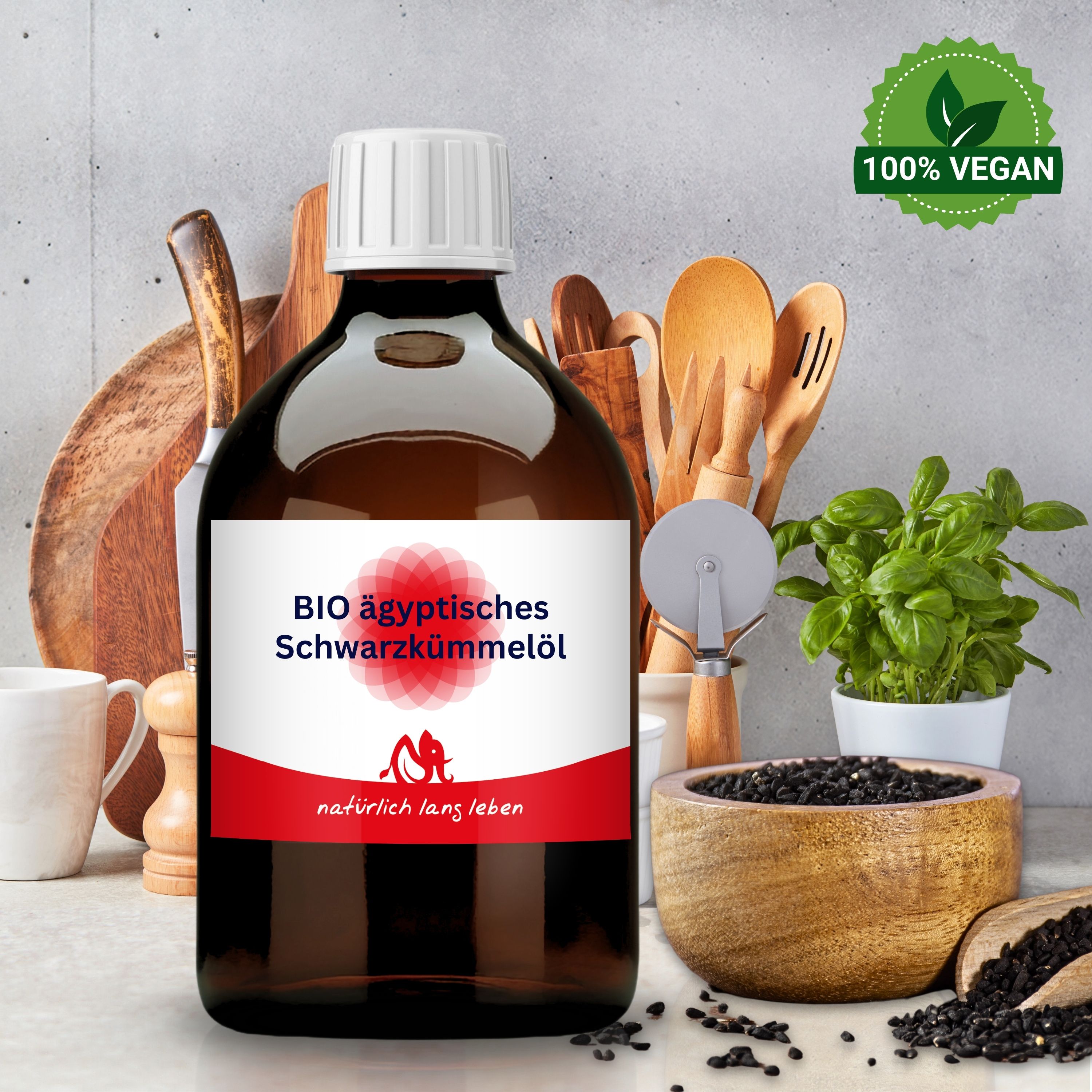 Braune Glasflasche mit weißem Deckel und Etikett. Flasche steht vor Küchenutensilien und Schüssel mit Schwarzkümmelsamen. 100% Vegan.