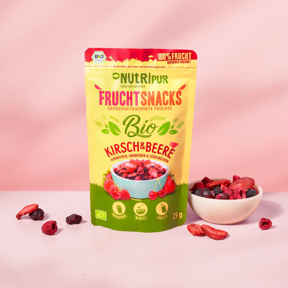 Gelbe Tüte mit Aufschrift "NutriPur Fruchtsnacks Bio Kirsch & Beere". Daneben Schale mit gefriergetrockneten Früchten. Bio-Siegel.