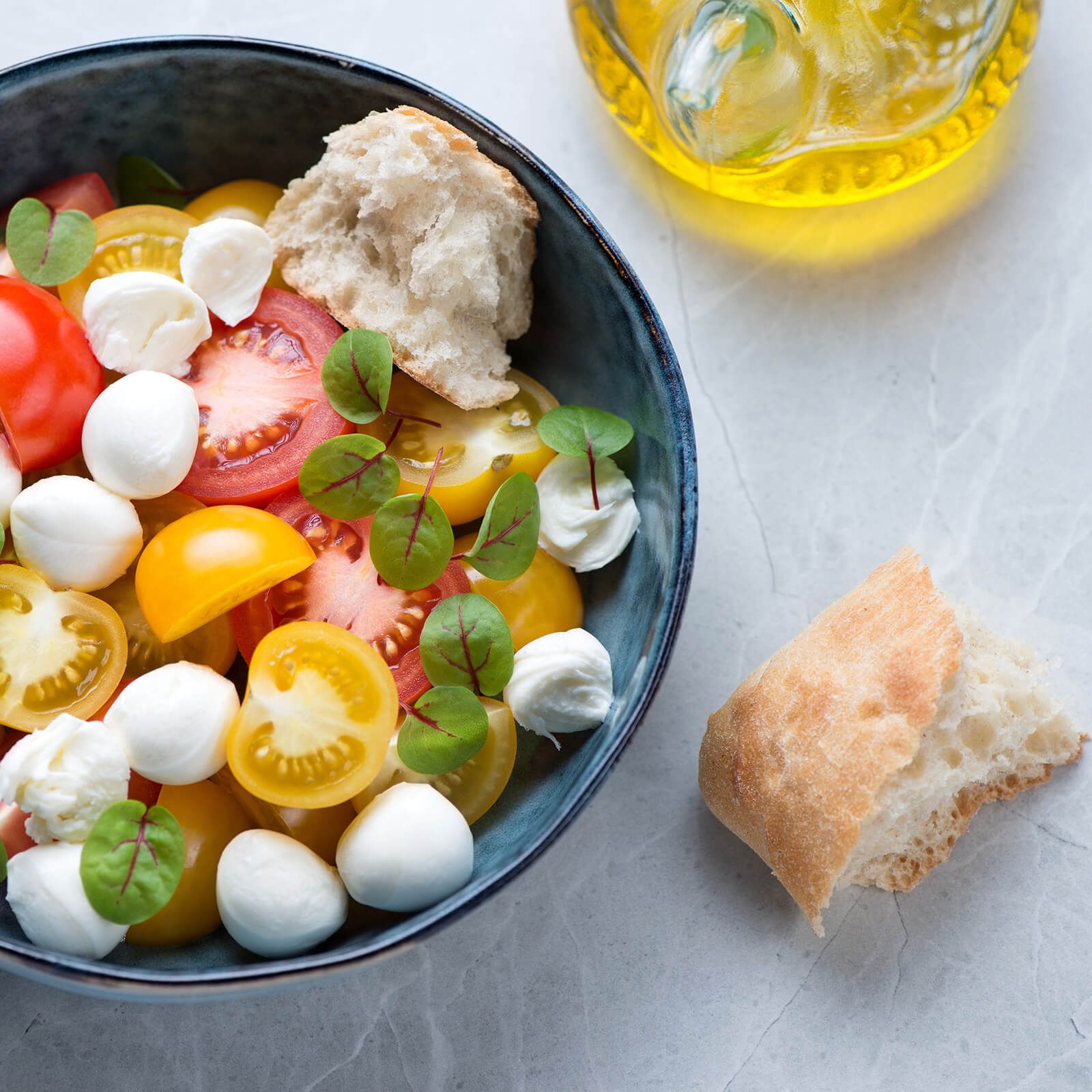 Salat mit Tomaten, Mozzarella-Kugeln und Ciabattini-Stückchen.
