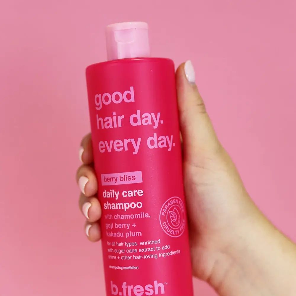 Rote Shampoo-Flasche, gehalten von einer Hand. Aufschrift: good hair day. every day. Mit Cruelty Free-Siegel.