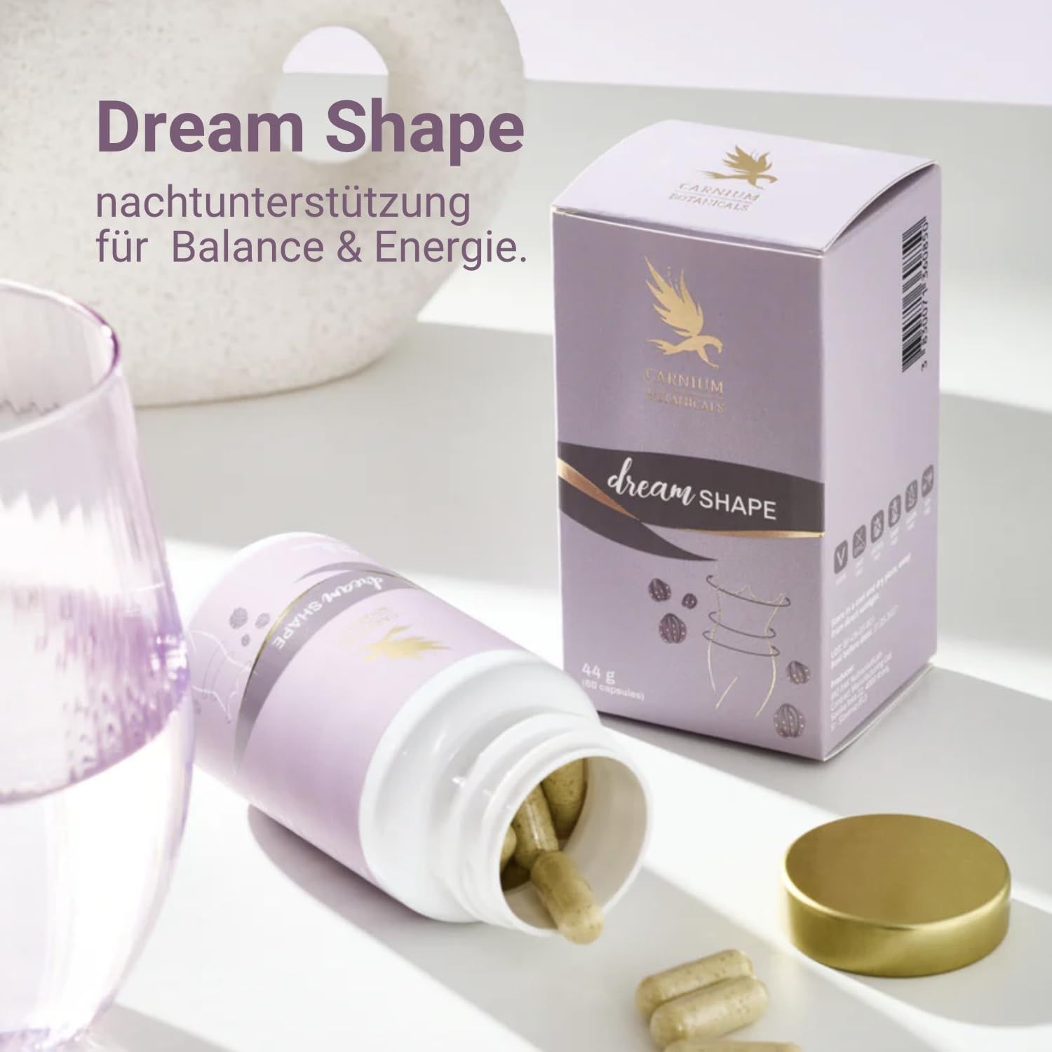 Dream Shape Flasche und Schachtel. Kapseln liegen daneben. Goldener Deckel. Lila Etikett mit Logo und Aufschrift Dream Shape.