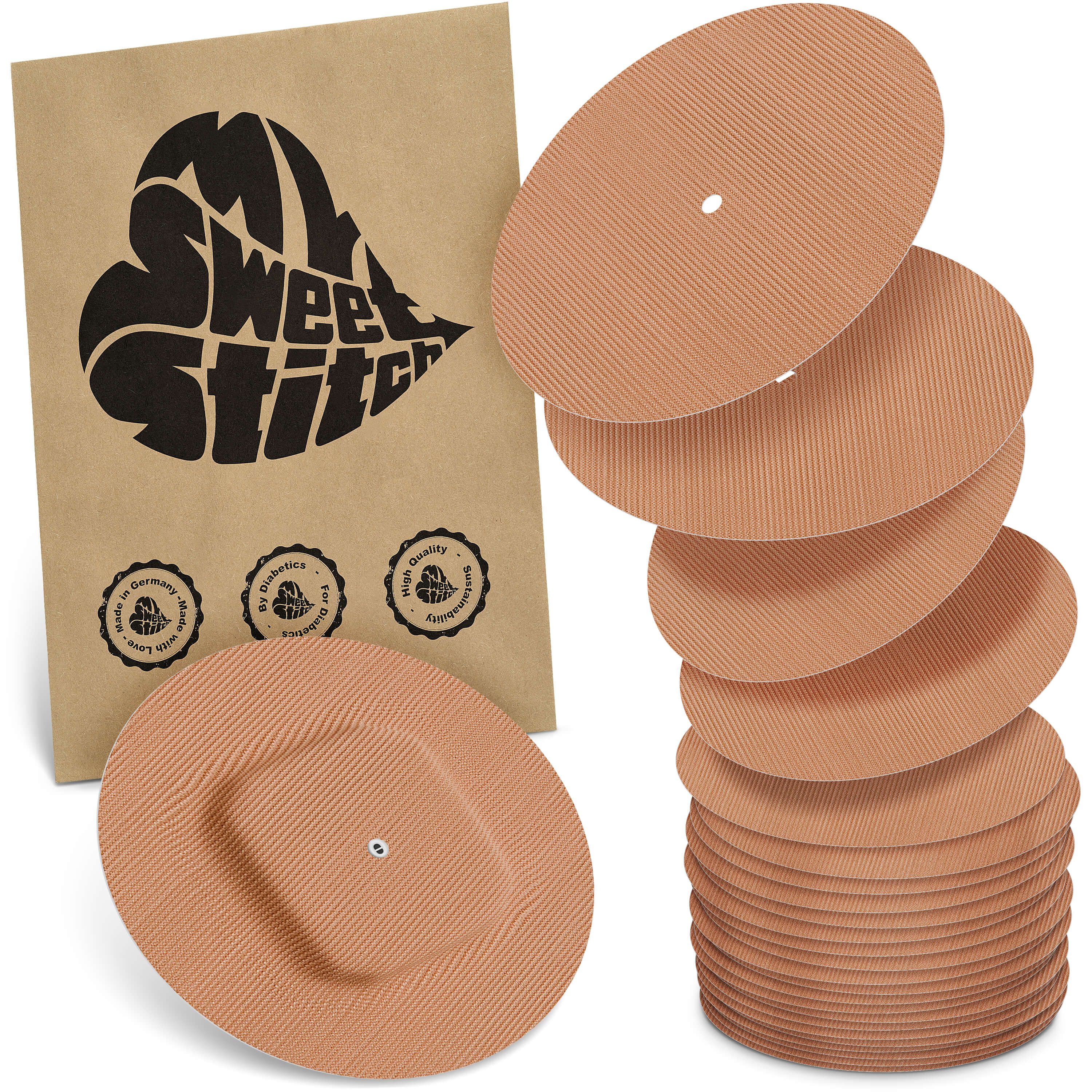 Mehrere runde Pflaster mit einem quadratischen Mittelteil, zusammen mit einer braunen Verpackung mit Logo.