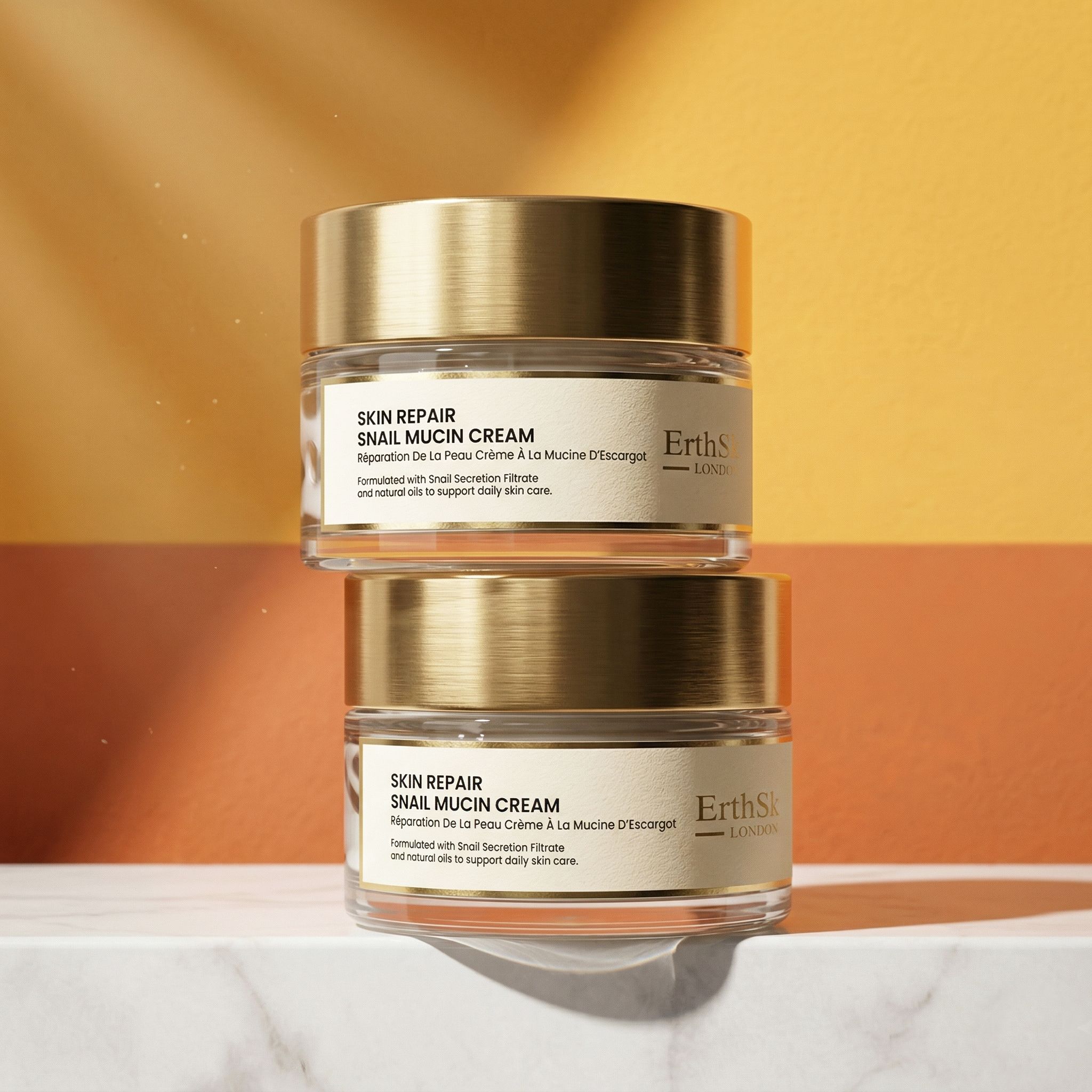 Zwei Glasbehälter mit goldfarbenen Deckeln. Aufschrift: Skin Repair Snail Mucin Cream. Marke: ErthSkin London.
