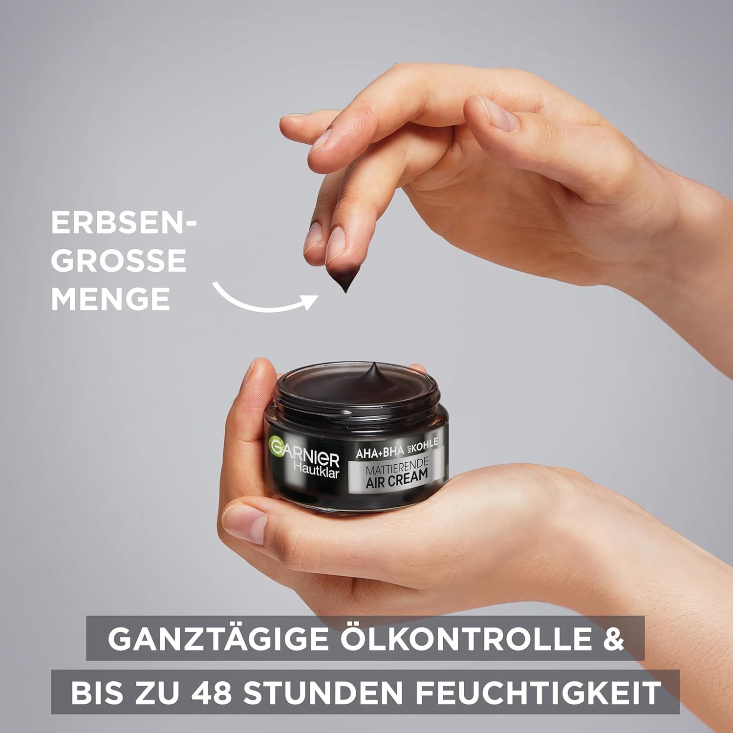 Hände halten Tiegel Garnier Hautklar Creme. Pfeil zeigt auf erbsengroße Menge Creme.