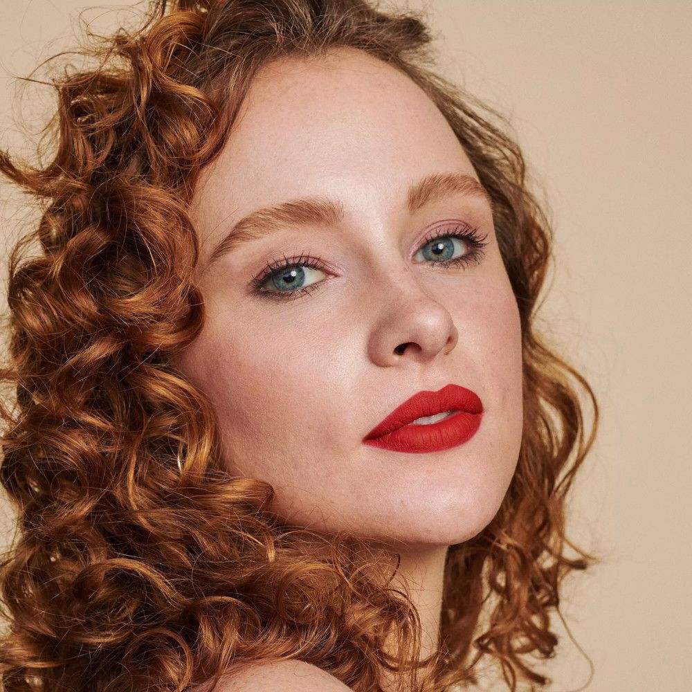Porträt einer Frau mit roten Lippen. Rotes Haar, blaue Augen.