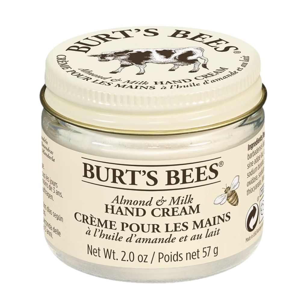 Cremebehälter mit Deckel. Aufschrift: Burt's Bees, Mandel & Milch Handcreme. Glasbehälter mit cremiger Substanz.