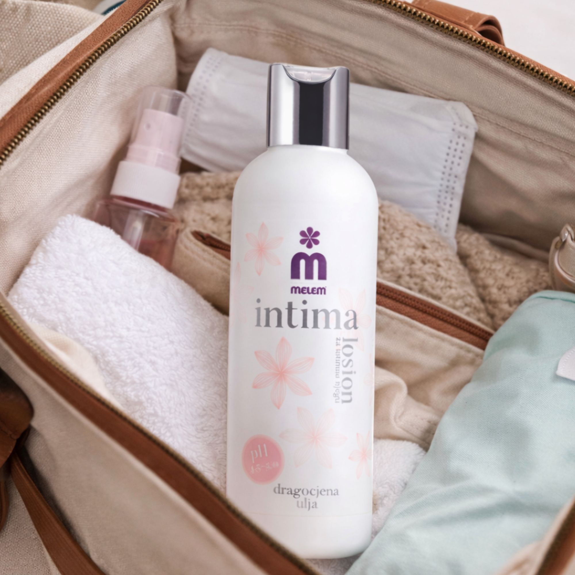 Weiße Flasche Intimpflege-Lotion in einer Tasche. Aufschrift: Intima, Melem, Lotion. Mit anderen Pflegeprodukten.