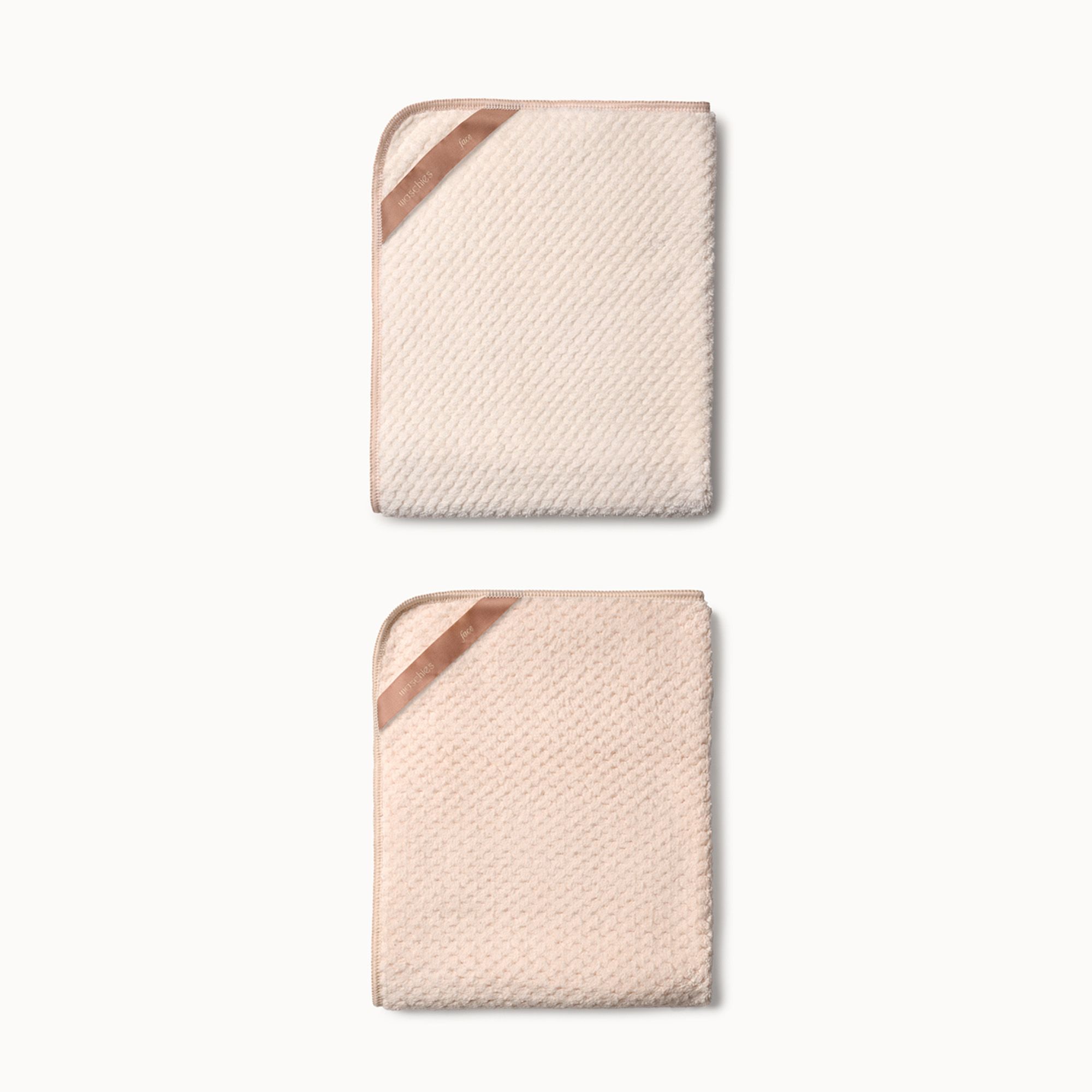Zwei quadratische Handtücher mit abgerundeten Ecken. Beige und rosa, mit braunen Bändern an einer Ecke.