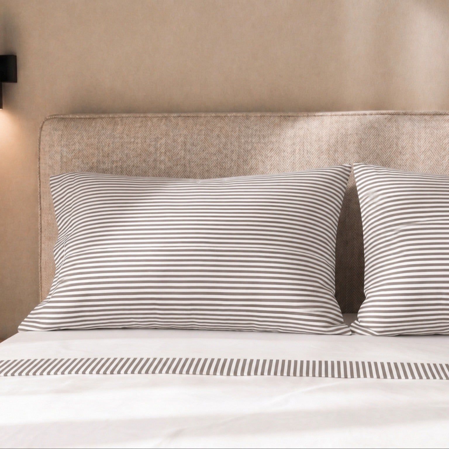 Gestreifte Kissenbezüge auf einem Bett mit gestreiftem Bettlaken.