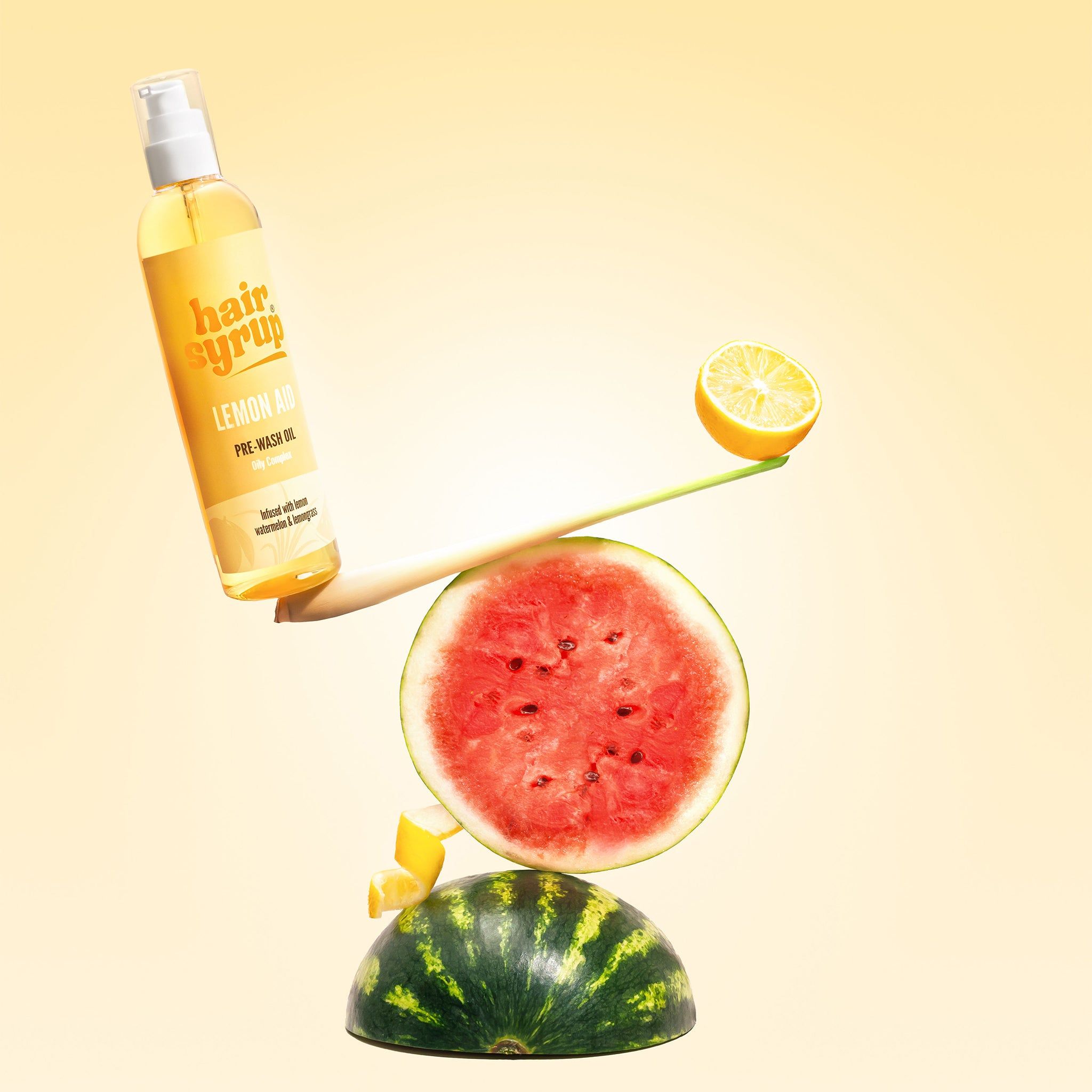 Gelbe Flasche mit Produktname, balanciert mit Wassermelone und Zitrone. Gelber Hintergrund.