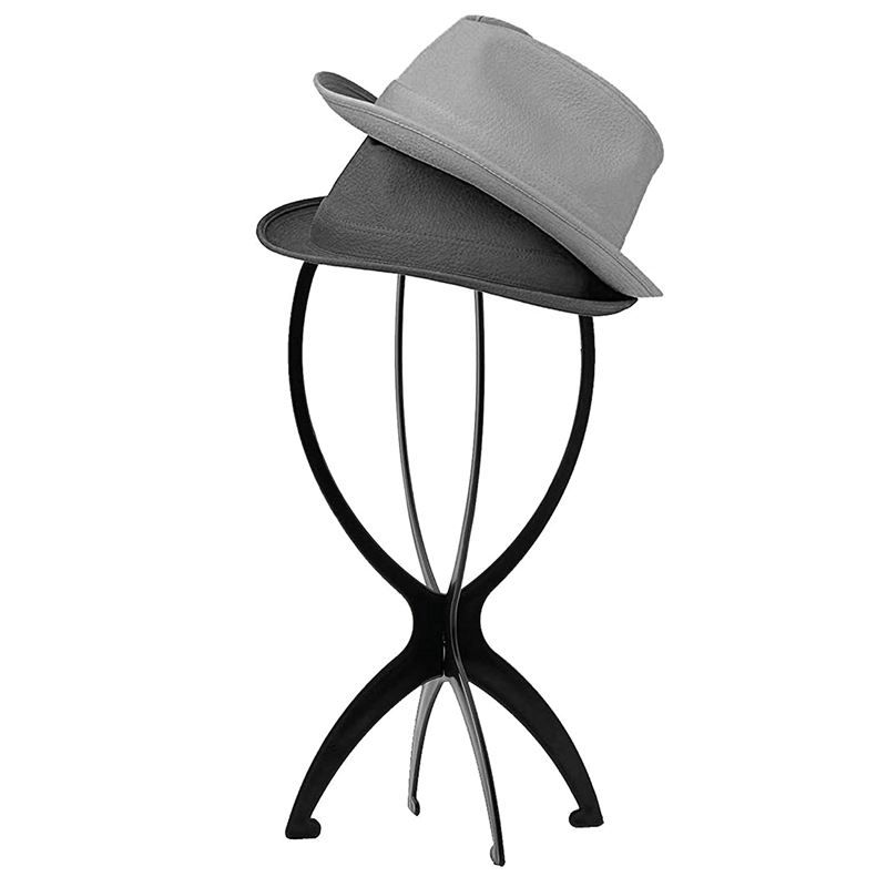 Schwarzer Perückenhalter mit zwei Hüten. Der Halter hat ein geschwungenes Design mit drei Beinen. Grauer und schwarzer Hut.