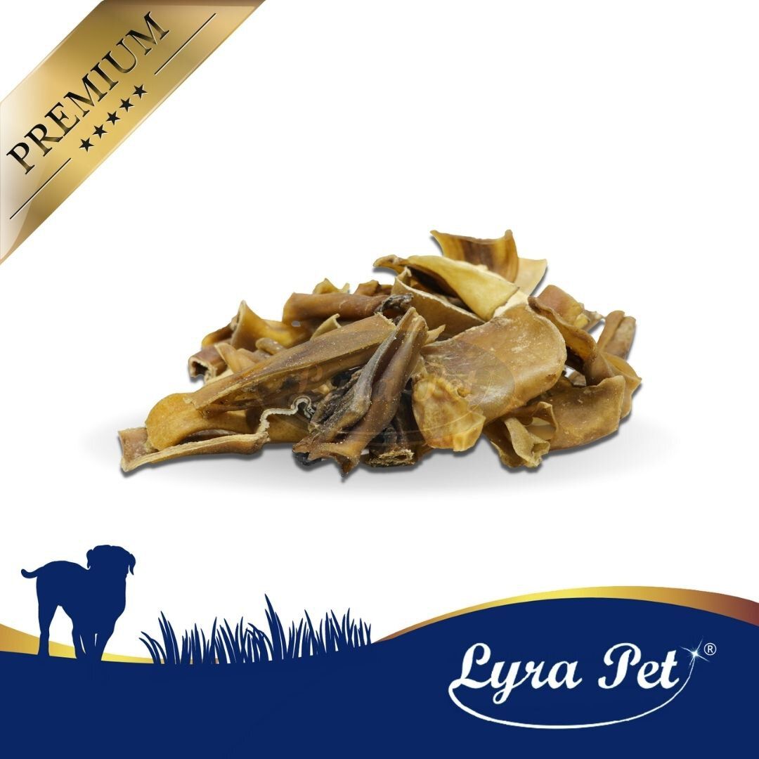 Haufen getrockneter Rinderkopfhaut Abschnitte. Auf weißem Hintergrund. Logo Lyra Pet unten rechts. Goldener Premium-Streifen oben links.