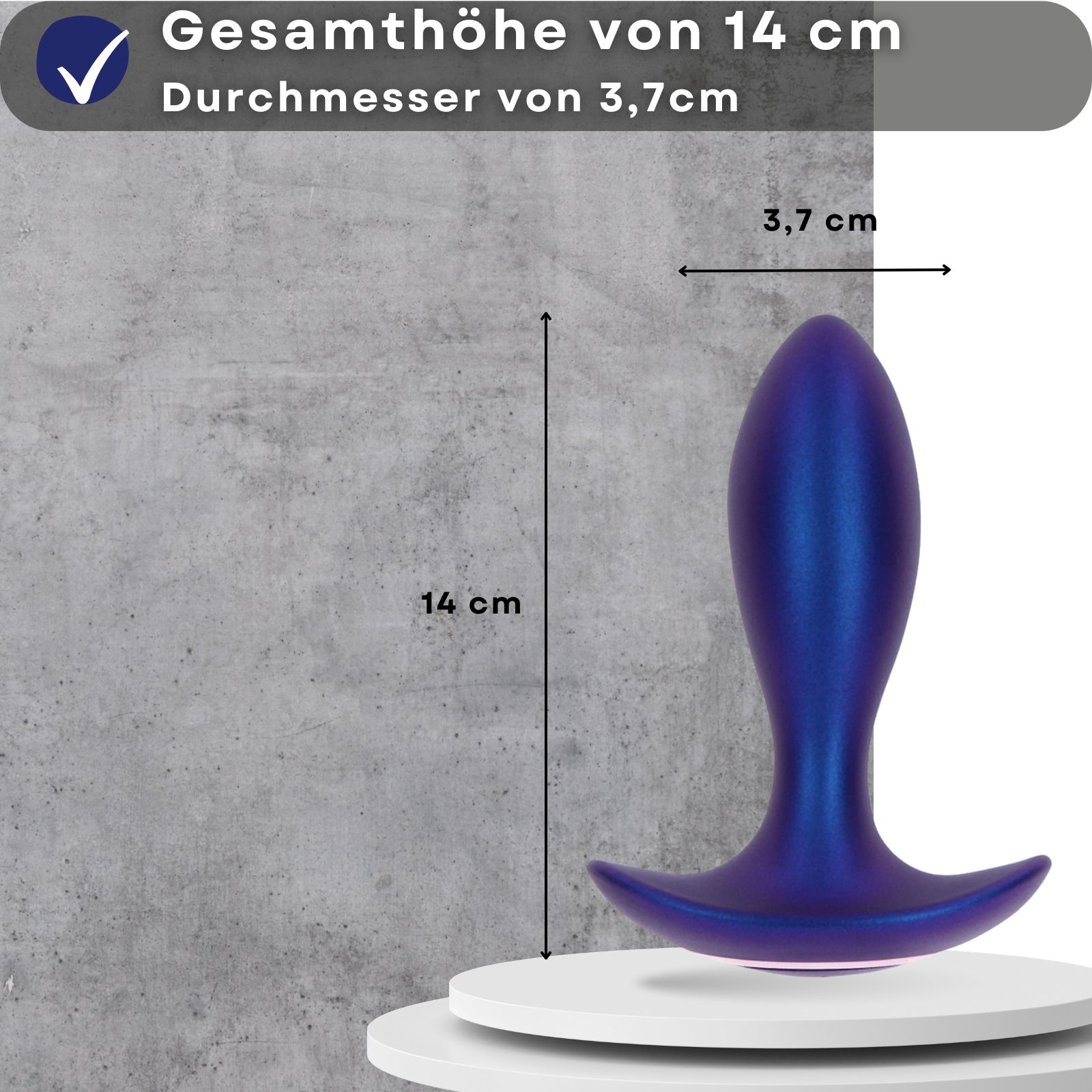 Blauer Analplug. Gesamthöhe 14 cm, Durchmesser 3,7 cm. Auf weißem Podest. Hintergrund: graue Wand.