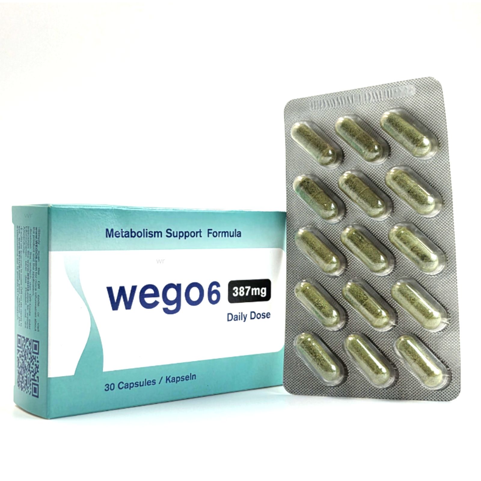 Blisterpackung mit Kapseln und Schachtel. Auf der Schachtel steht "Wego6", "387mg Daily Dose" und "30 Capsules / Kapseln".