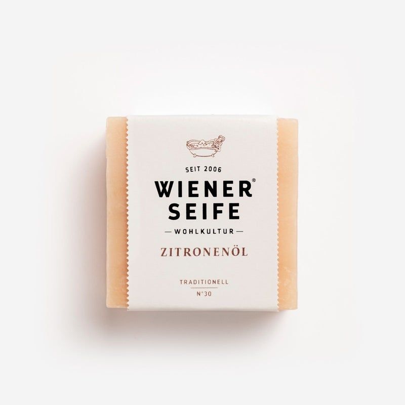 Seife mit Papierbanderole. Aufschrift: Wiener Seife, ZITRONENÖL, N°30. Beige Seife, weißes Papier. Traditionell.