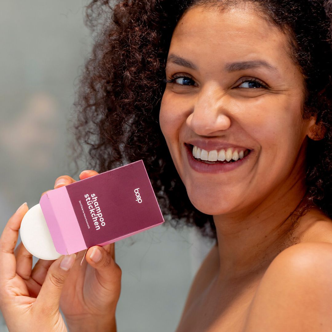 Frau hält ein boep Shampoostückchen und die Verpackung.
