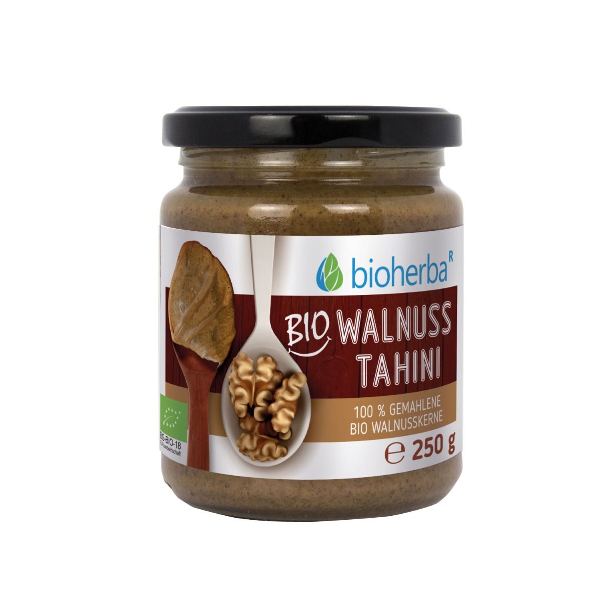Glas mit Bio Walnuss Tahini. Schwarzer Deckel, Etikett mit Produktinformationen und Logo. 250 g.