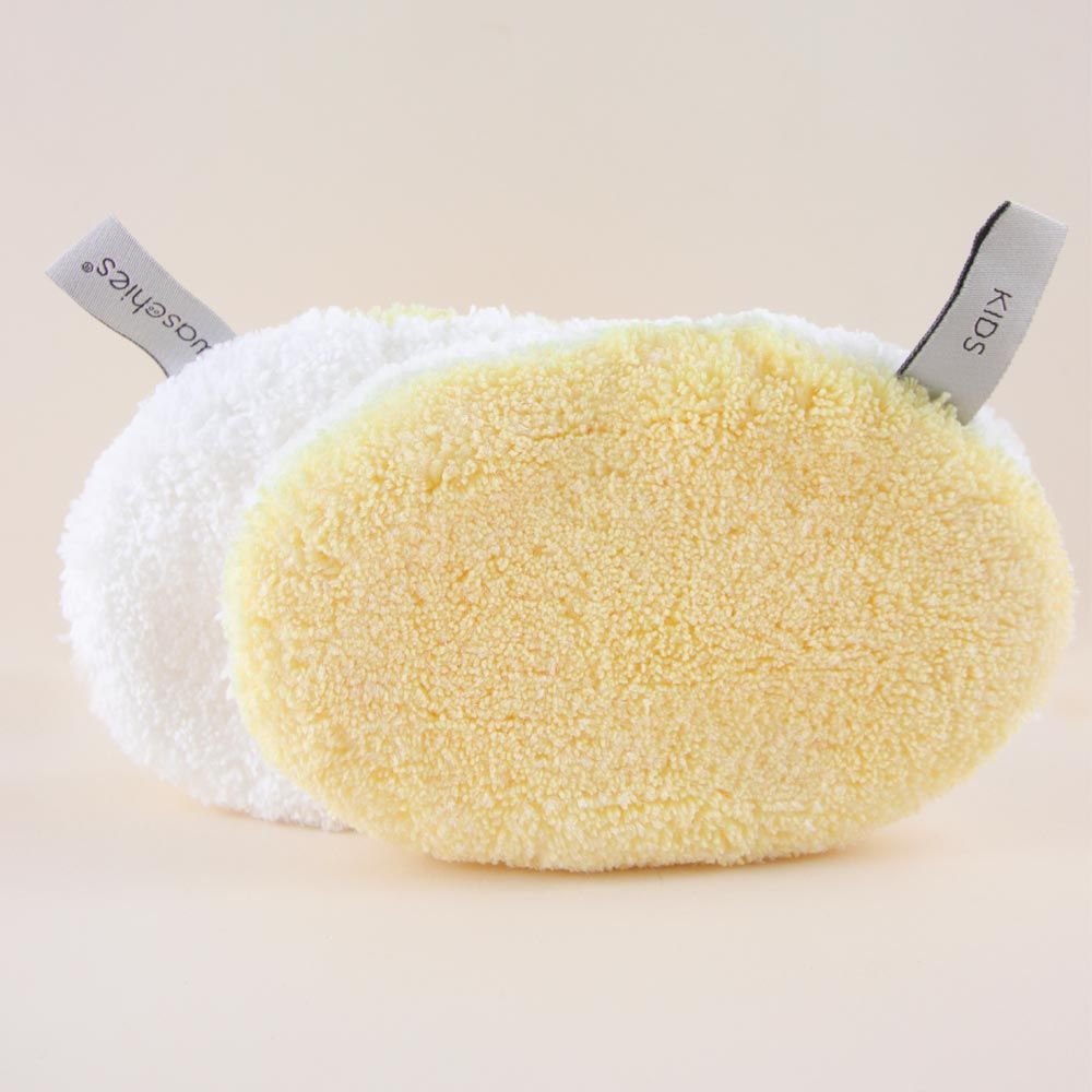 Zwei ovale Waschpads, weiß und gelb, mit Etiketten "waschies" und "KIDS".