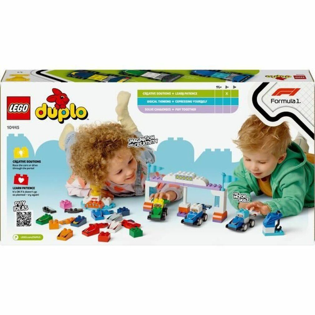 Kinder spielen mit LEGO DUPLO F1 Rennautos auf einer Rennstrecke.