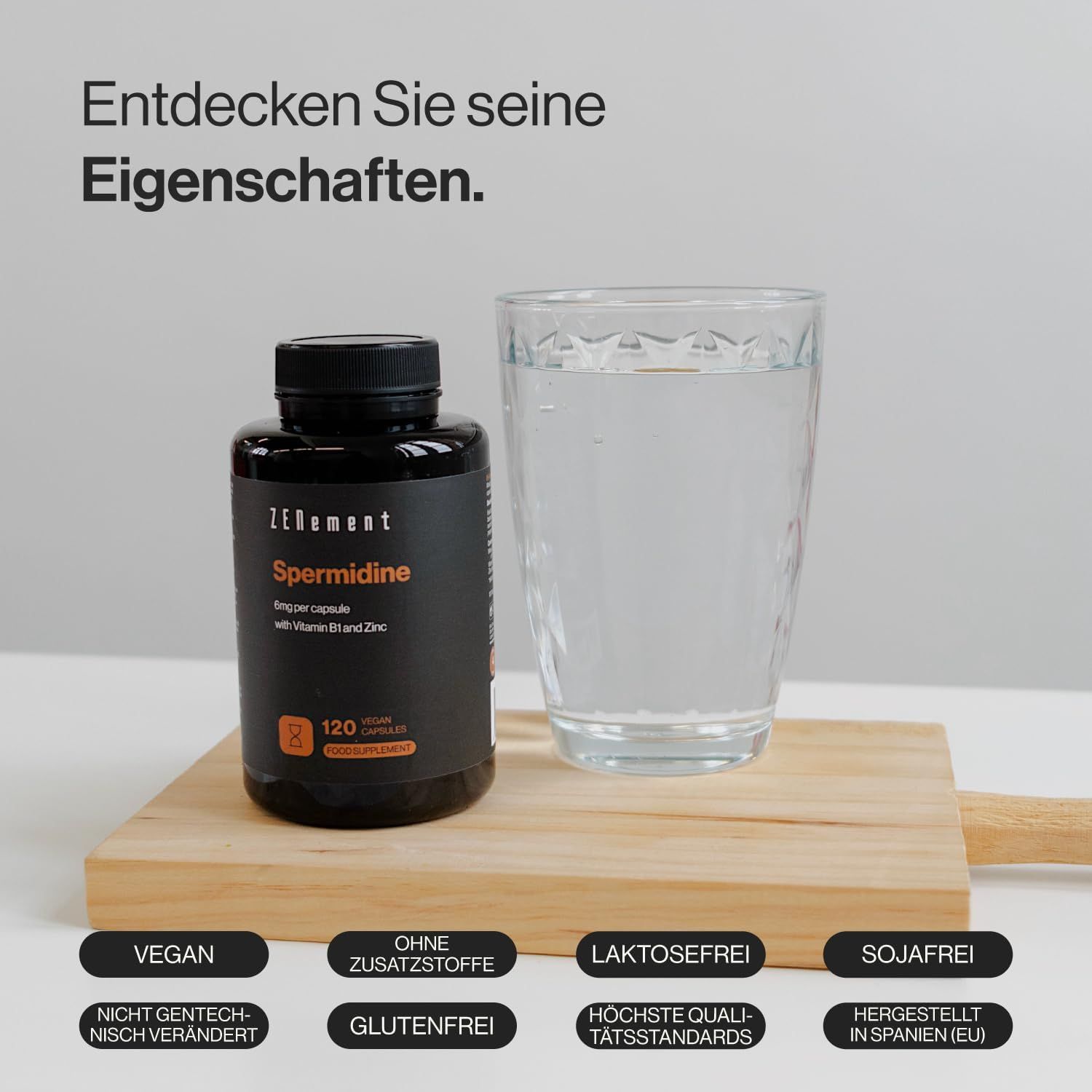 Zenement Spermidin Kapseln neben Glas Wasser auf Holzbrett. Text: Vegan, ohne Zusatzstoffe, laktosefrei, sojafrei, nicht gentechnisch verändert, glutenfrei.