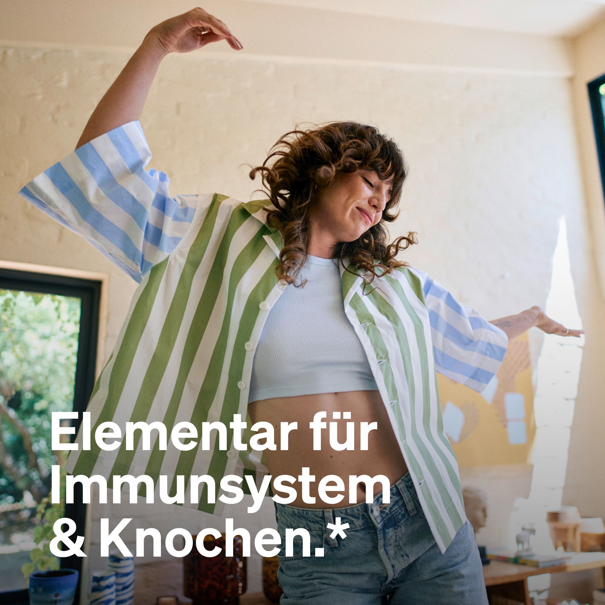 Eine Frau tanzt mit erhobenen Armen. Text: "Elementar für Immunsystem & Knochen."