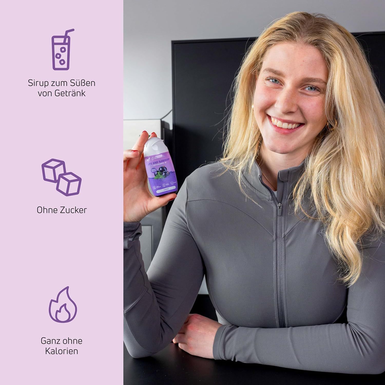 Frau hält Flasche mit Produkt. Aufschrift: Ohne Zucker, Ganz ohne Kalorien. Produkt: Sirup zum Süßen von Getränken.