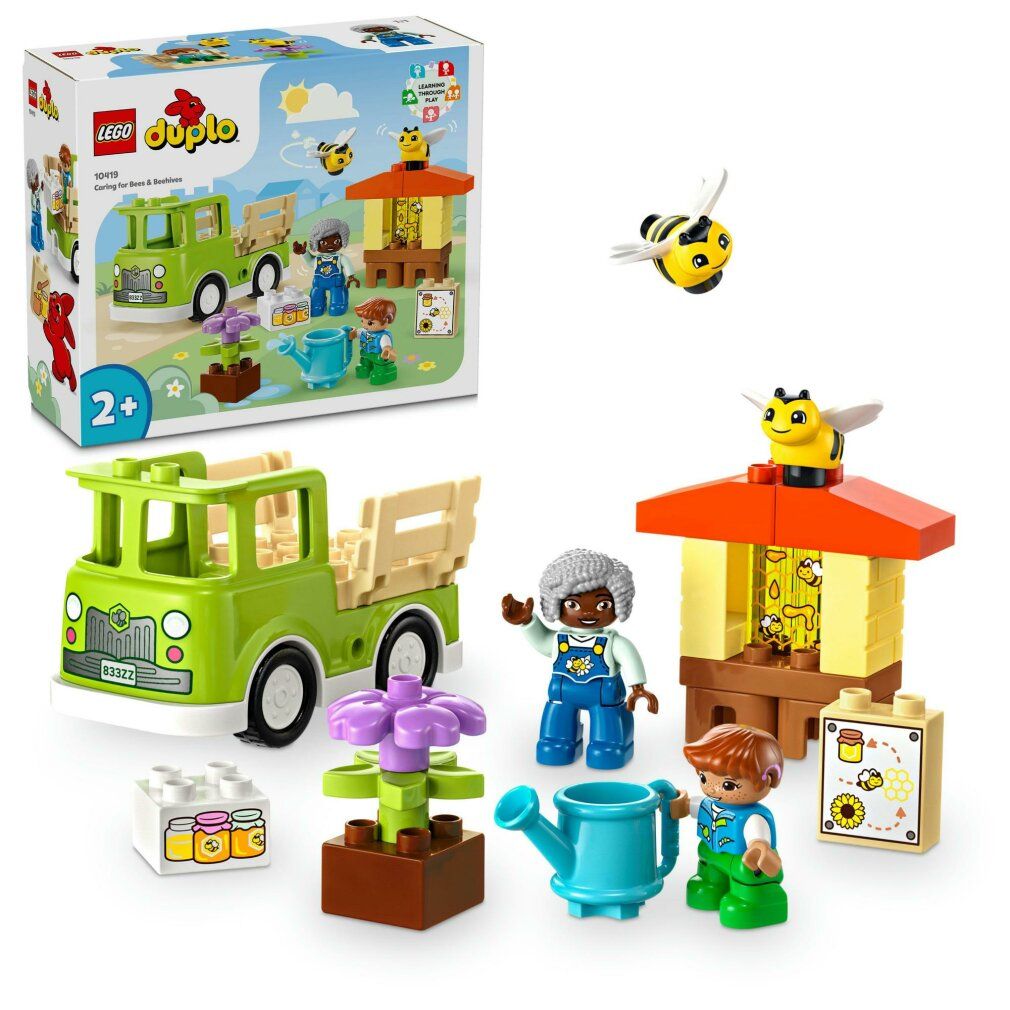 LEGO DUPLO Set mit LKW, Figuren, Bienenhaus, Blumen, Gießkanne und Bienen. Altersempfehlung: 2+. Einzelteile liegen daneben.