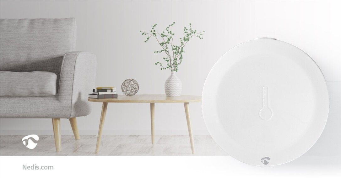 Weißer, runder Sensor mit Thermometer-Symbol. Nedis-Logo unten links. Auf Tisch platziert.