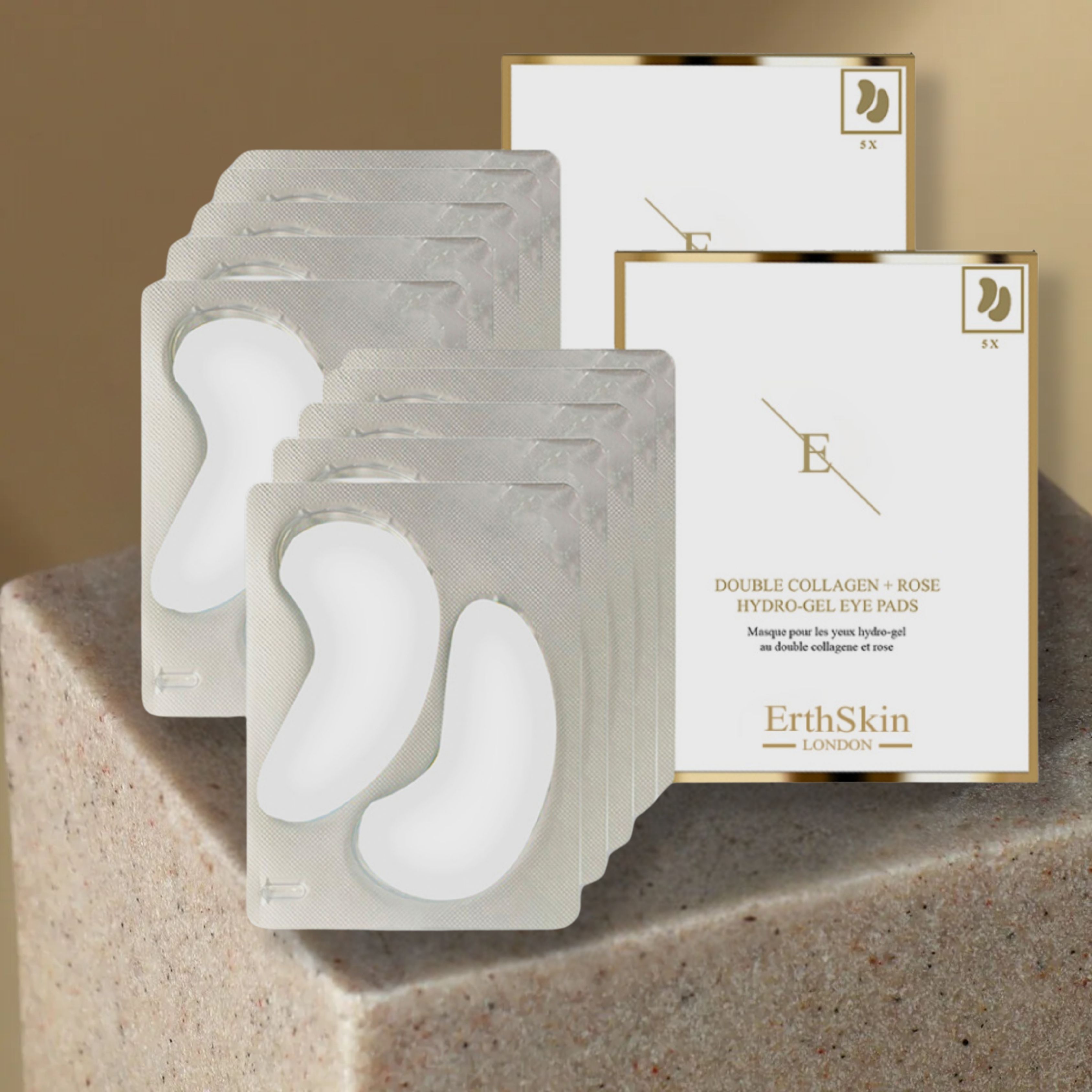 Augenpad-Set. Weiße, halbmondförmige Pads in transparenten Blistern. Verpackung mit goldfarbenem Rahmen. Text: Double Collagen + Rose.