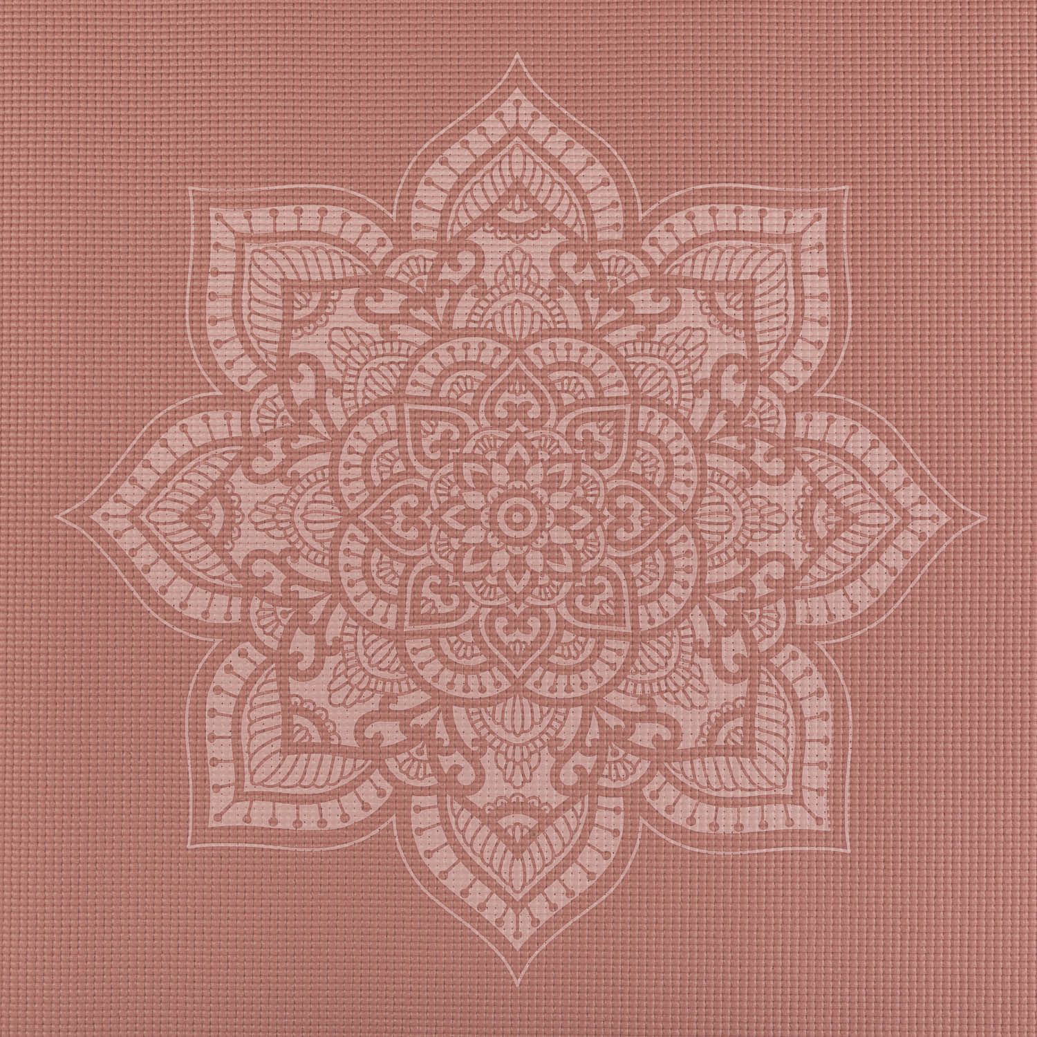 Nahaufnahme eines Mandala-Musters auf einer rosafarbenen Yogamatte. Weißes Mandala-Design. Geriffelte Oberfläche.