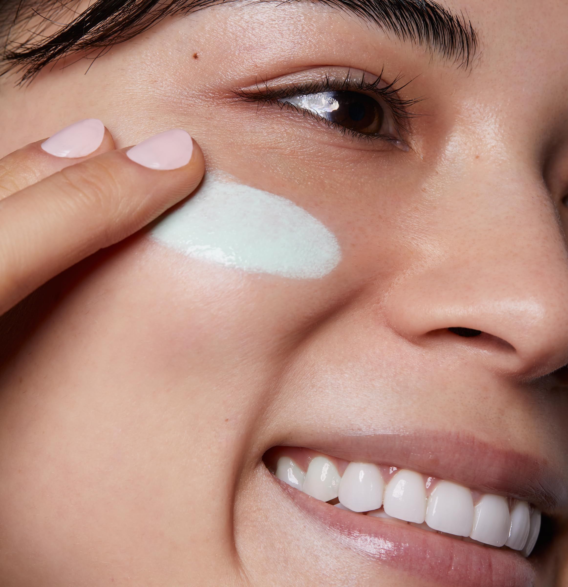 Frau trägt grünes Produkt auf. Gesicht, Nahaufnahme.