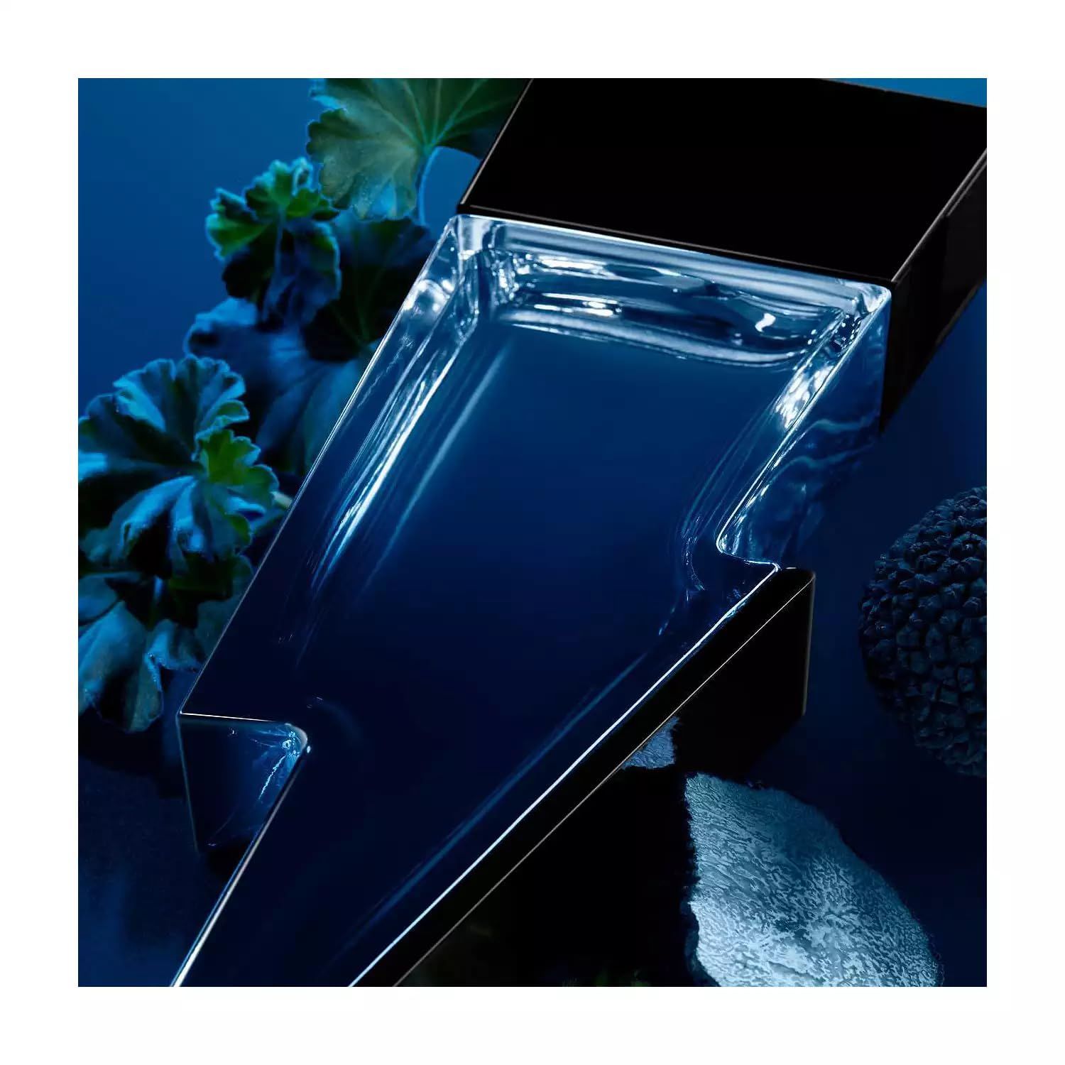 Blauer Flakon in Blitzform, gefüllt mit Flüssigkeit. Schwarzer Deckel. Auf blauem Untergrund mit Blättern und einer Kugel.