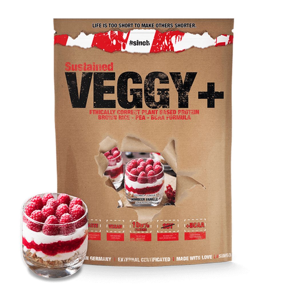 Braune Tüte mit Aufschrift VEGGY+ und Produktinformationen. Daneben ein Glas mit Himbeeren und Creme.