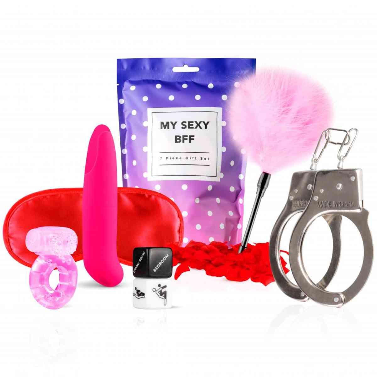 Set mit Augenmaske, Ring, Vibrator, Peitsche, Handschellen, Gleitmittel und Geschenkbeutel. Rosa, rot und silberne Elemente.