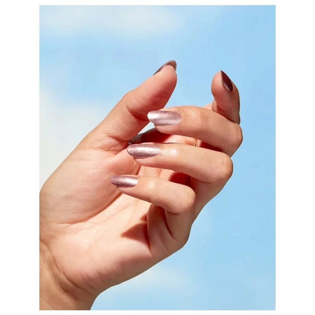 Hand mit lackierten Nägeln in Roségold. Blauer Hintergrund.