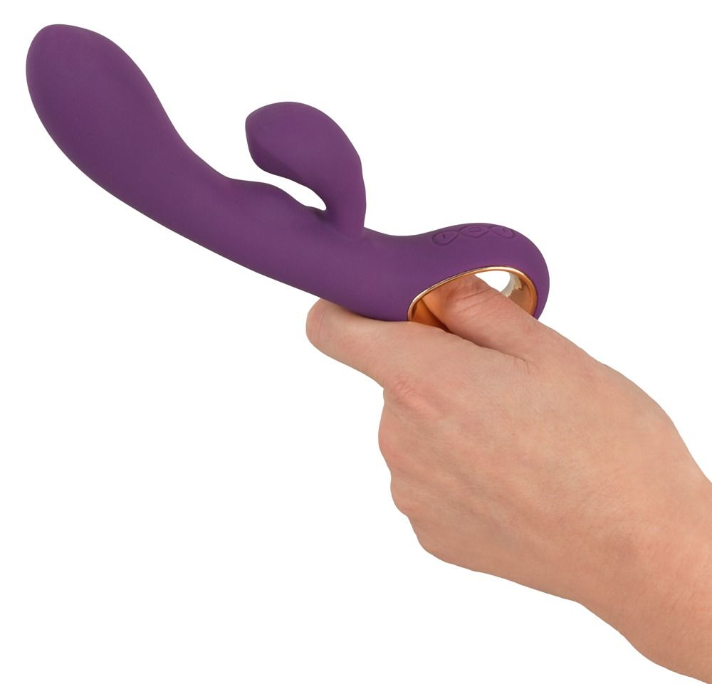 Lila Vibrator mit zwei Motoren, gehalten von einer Hand, Finger im Ring.