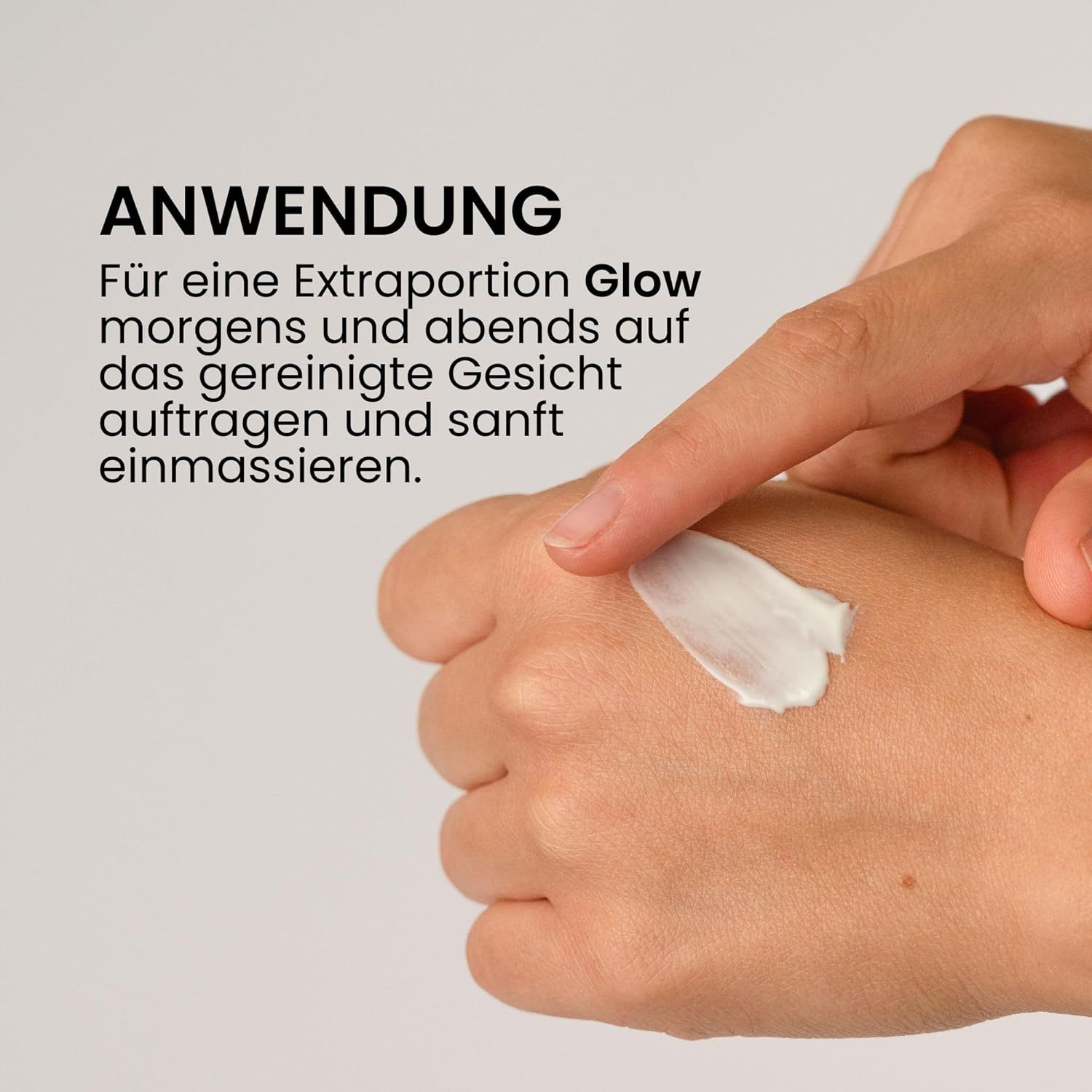 Hände mit Creme. Ein Finger berührt eine kleine Menge Creme auf der Handfläche. Text: Anwendung.