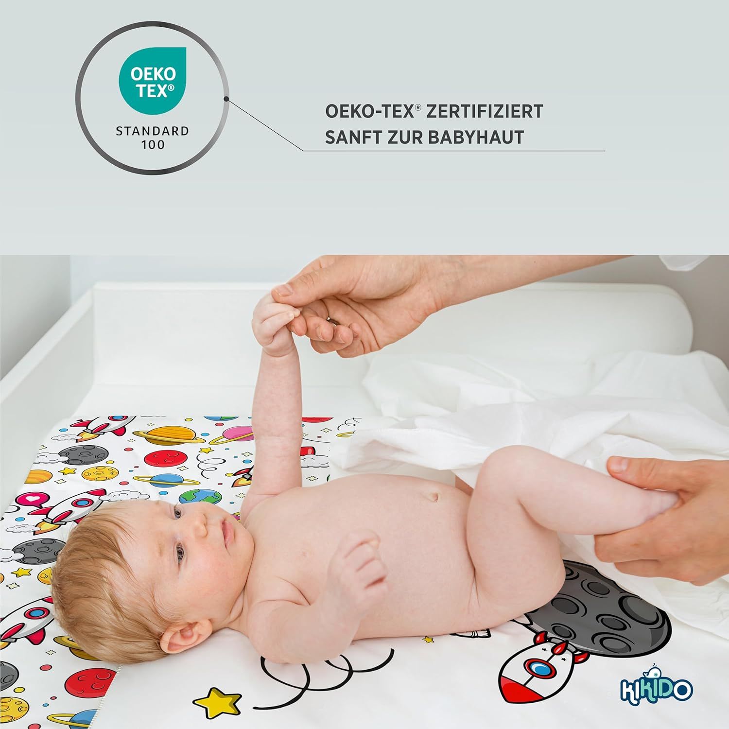 Baby auf Wickelauflage. Oeko-Tex Standard 100 Zertifizierung. Sanft zur Babyhaut. Kikido Logo.