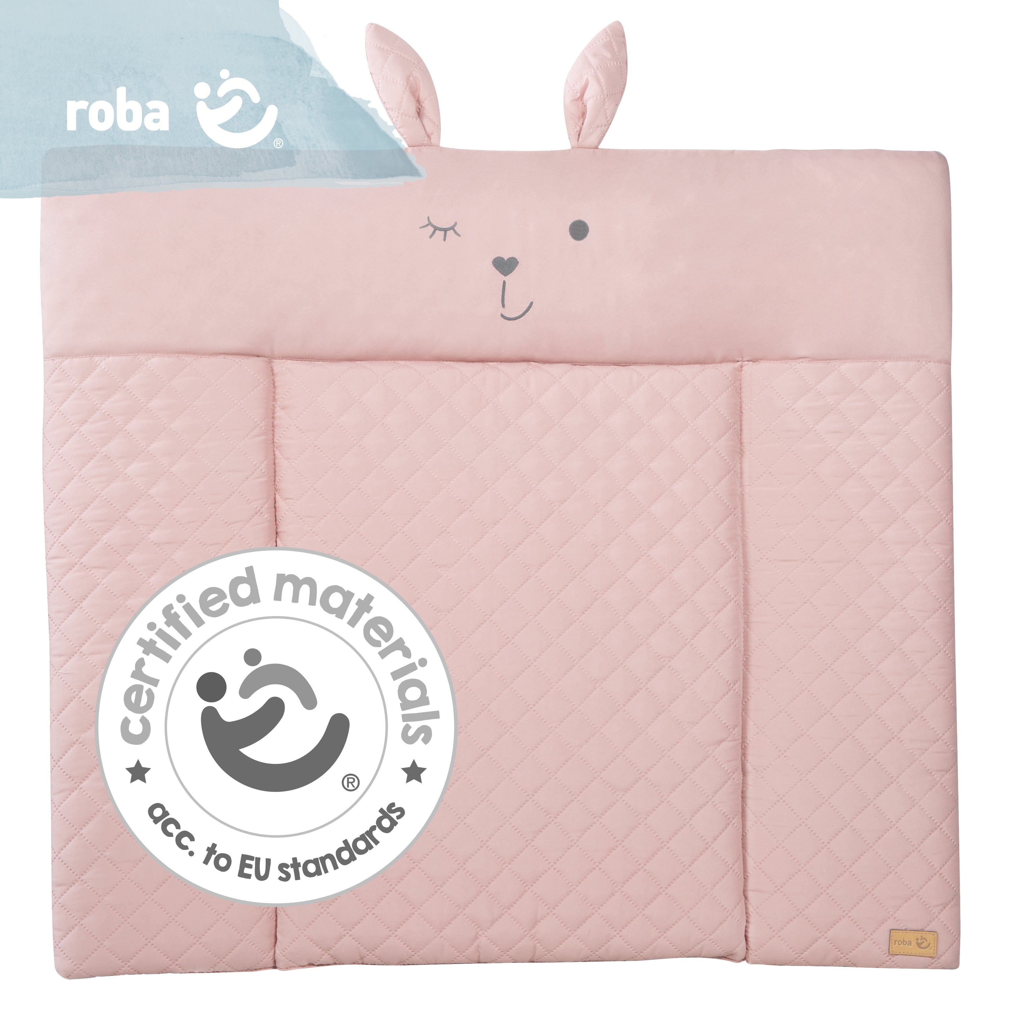 Rosa Wickelauflage mit Hasenohren und Gesicht. Label mit Logo und Schriftzug 'roba'. Siegel: 'certified materials'.