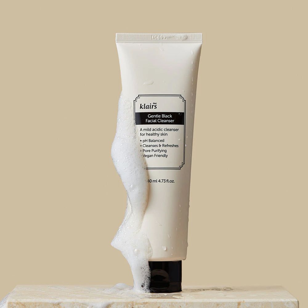 Tube mit Schaum. Aufschrift: Gentle Black Facial Cleanser. Vegan. Schaum fließt.