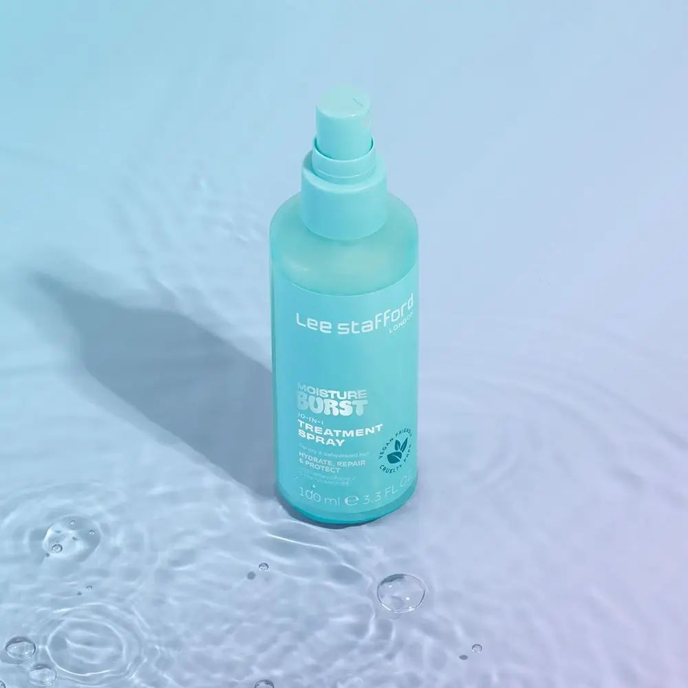 Türkisgrüne Sprühflasche mit weißem Etikett. Aufschrift: Moisture Burst. Steht im Wasser.