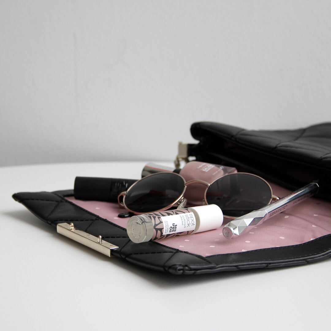 Spot Stick in einer Handtasche.  Klarer Behälter mit Roll-on-Applikator.  Markenname und Text sichtbar.