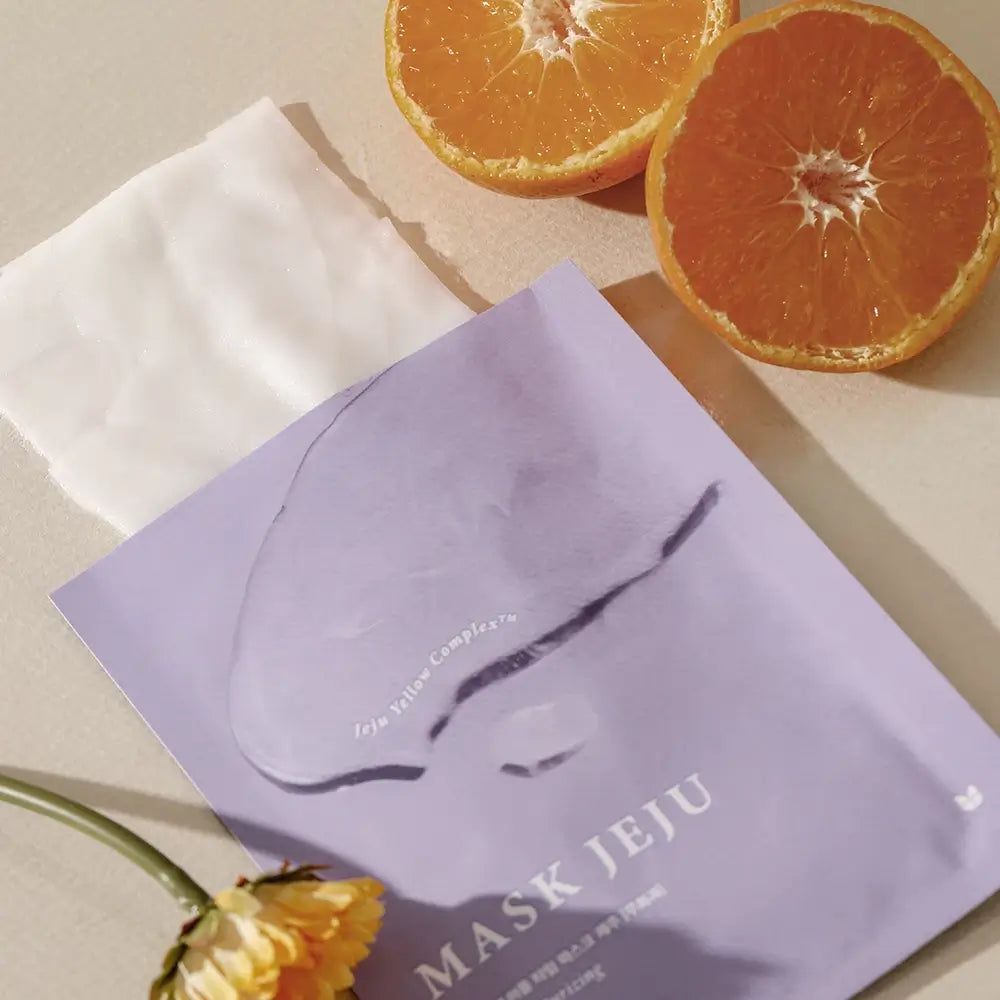 Violette MIZON Maske Jeju, daneben eine Maske und Orangen. Aufschrift: MASK JEJU. Mit Jeju Yellow Complex.
