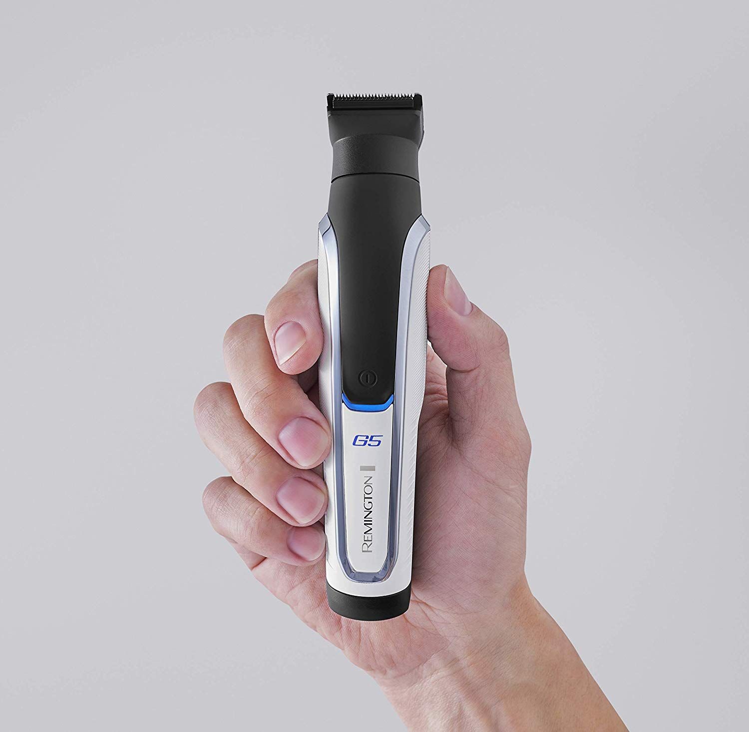 Haarschneider in Hand gehalten. Das Gerät ist schwarz, silber und weiß. Der Name Remington und die Bezeichnung G5 sind sichtbar.